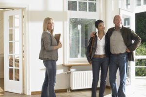 real estate agent showing empty house to a couple. wide angle.